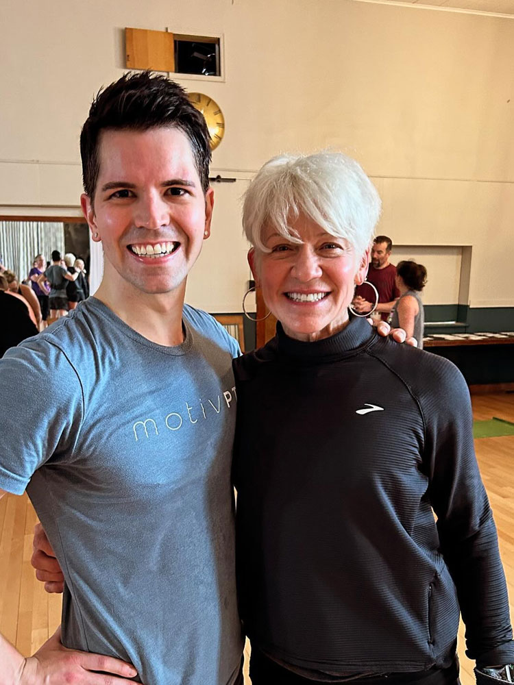 Dr. Alex standing with his mom in a gym